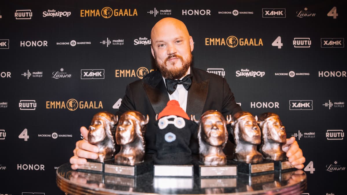 Pyhimys hymyilee kuuden Emma-palkintonsa edessä Emma-gaalan promoseinän edessä.