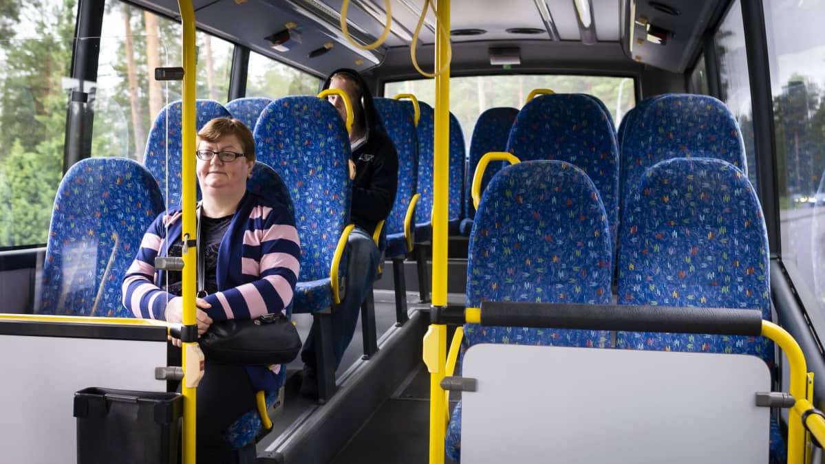 Ihmisiä liikkuvassa linja-autossa.