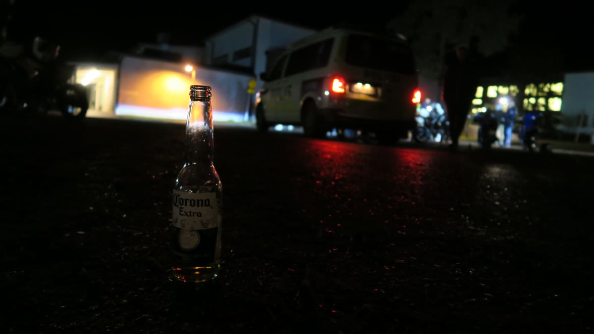 Corona-pullo asvaltilla pimeällä koulun pihalla.