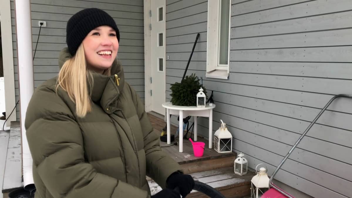Emmi Verronen seisoo kotipihassa hymyillen