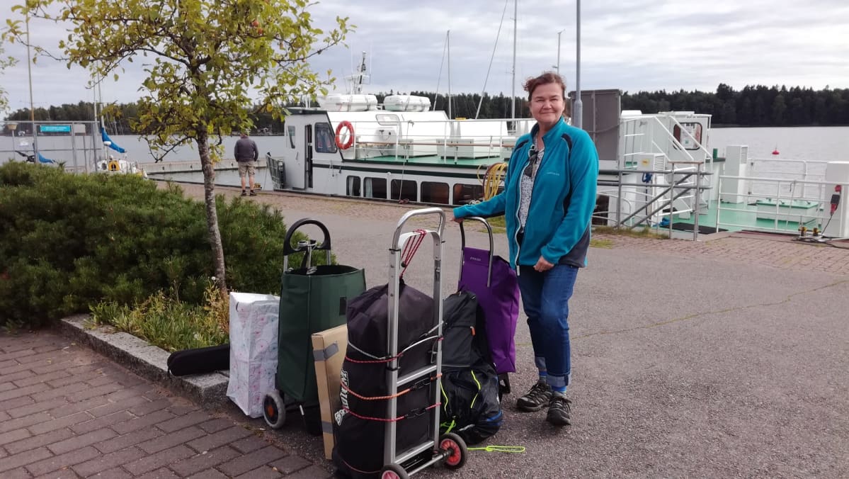 Pirjo Wiksten ja Kaunissaaresta tuodut tavarat venelaiturissa. Wikstenit ovat purkaneet telttapaikkansa Helsingin kaupungin velvoituksen mukaisesti ja palasivat keskiviikkona kaupunkikotiinsa.