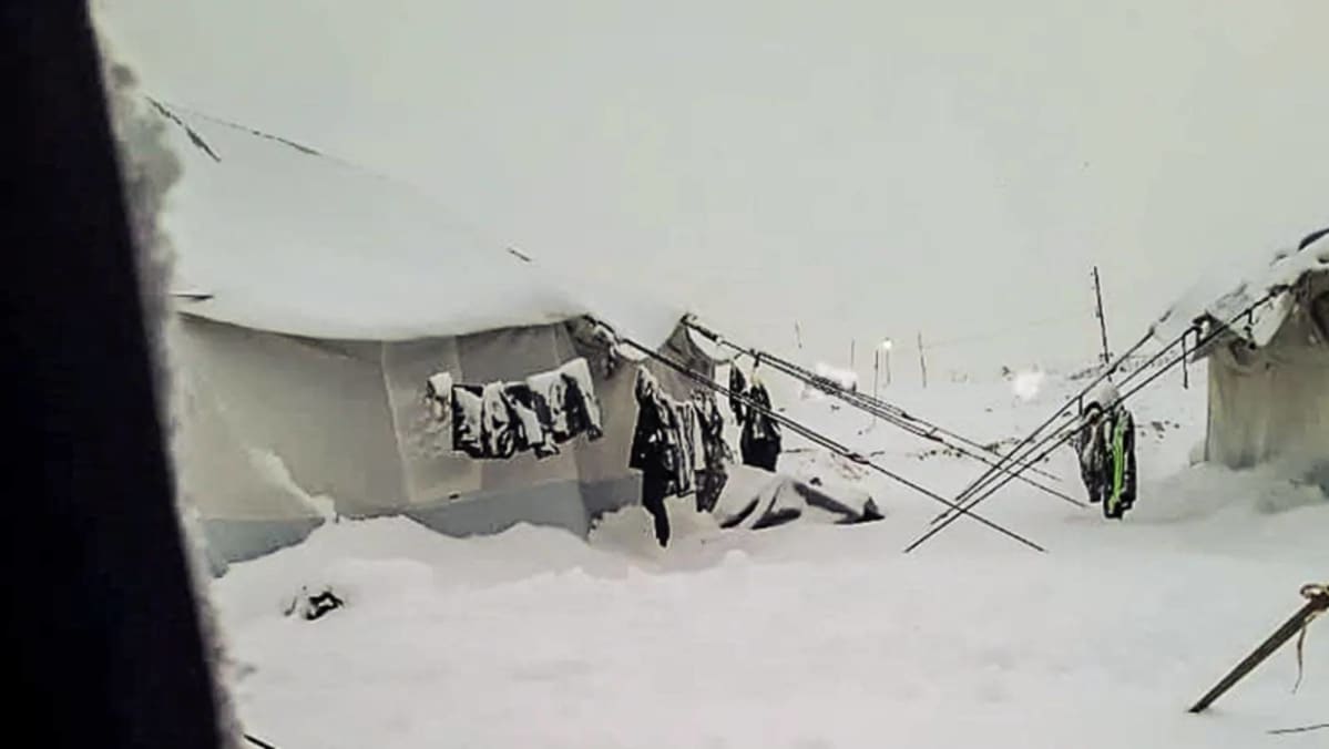 Snö på marken i al-Hol-lägret i Syrien. På bilden syns tält och kläder som händer utanför tälten. kläderna har också snö på sig.
