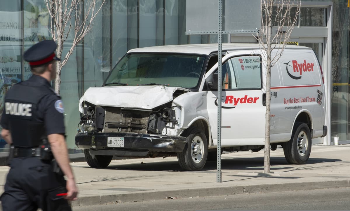 Ryder-yhtiön pakettiauton keula on ruttaantunut, poliisi kävelee läheltä ohi.