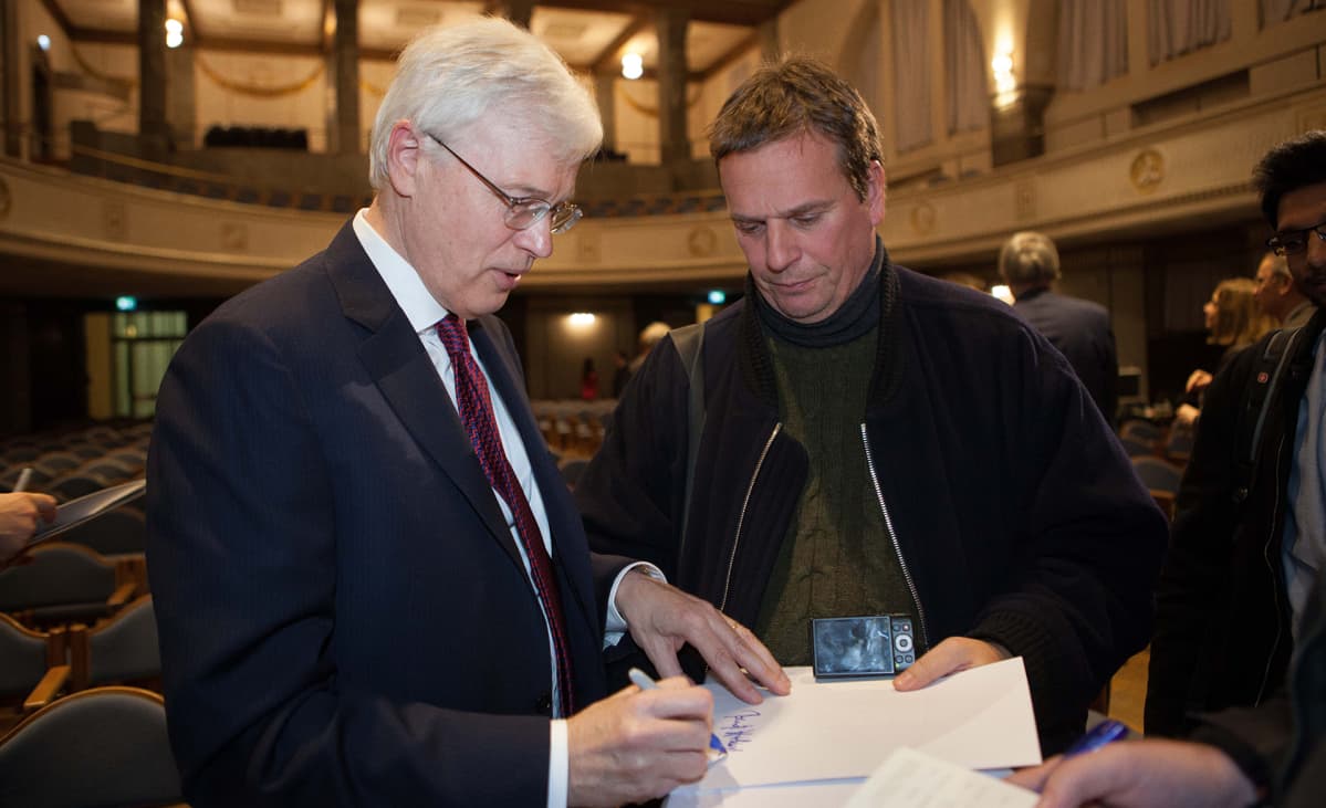 Professori Bengt Holmström jakaa nimikirjoituksia.
