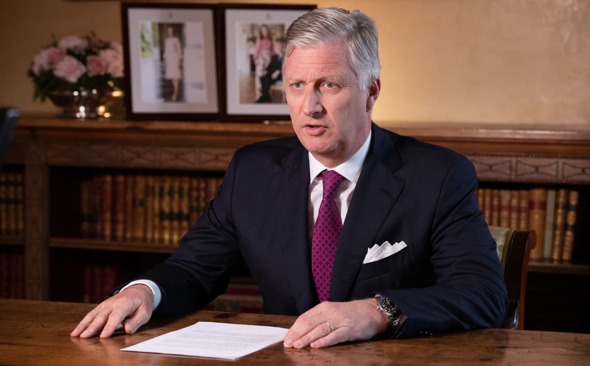Kuningas Philippe istumassa pöydän takana.