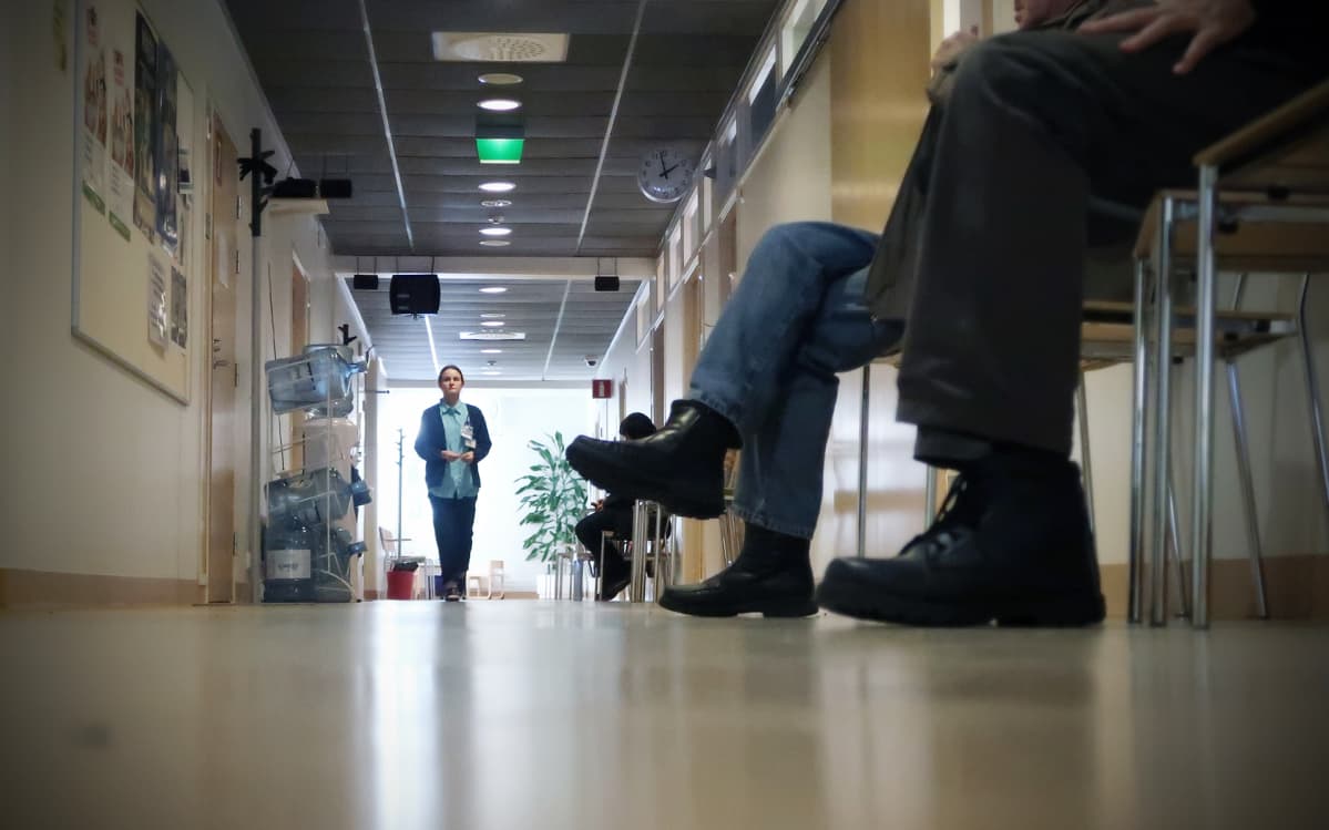 Asiakkaat jonottavat terveyskeskuksen käytävällä.