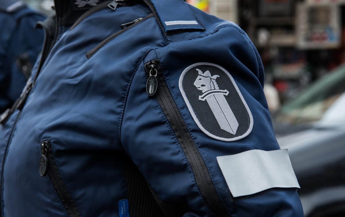 Poliisiin logo poliisi univormussa