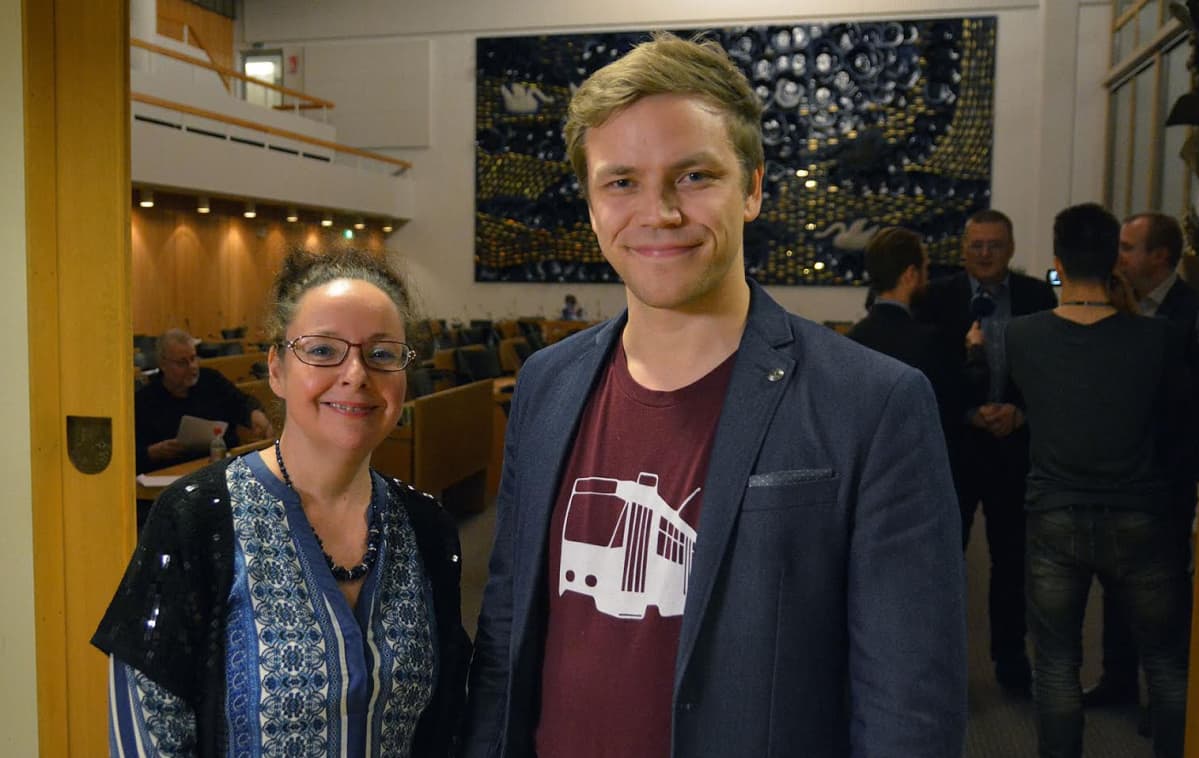 Tampereen kaupunginvaltuutetut Aila Dündar-Järvinen ja Jaakko Mustakallio seisovat valtuustosalin ovella.
