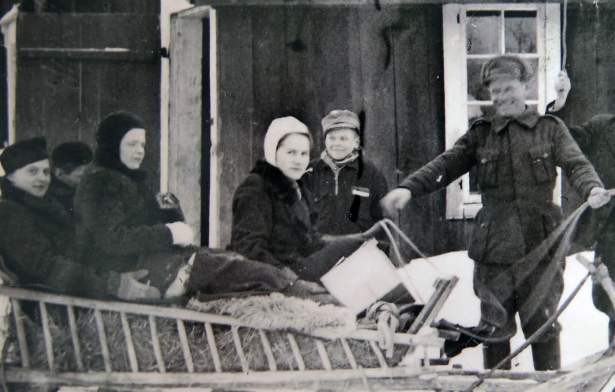 Vanha valokuva, jossa on naisia reessä.