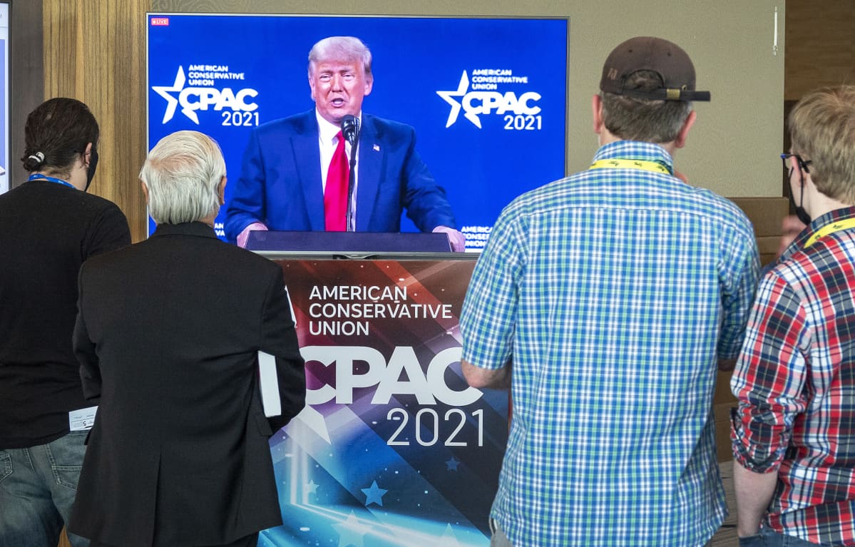 Ihmiset katselevat Donald Trumpin puhetta tv-screeniltä Orlandossa Floridassa.