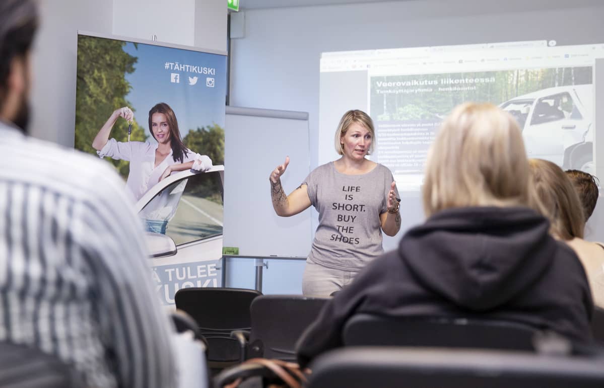 Autokoulun opettaja Minttu Vänni puhuu luokan edessä.