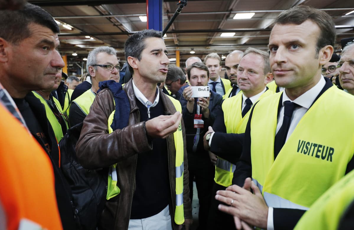 Emmanuel Macron suojaliivissä tehtaalla.