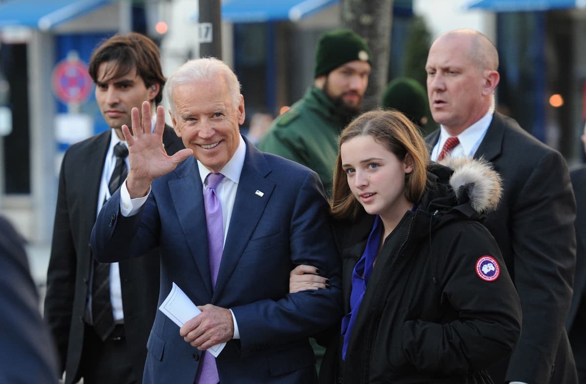 Biden vilkuttaa kameralle teinityttö käsipuolessaan.