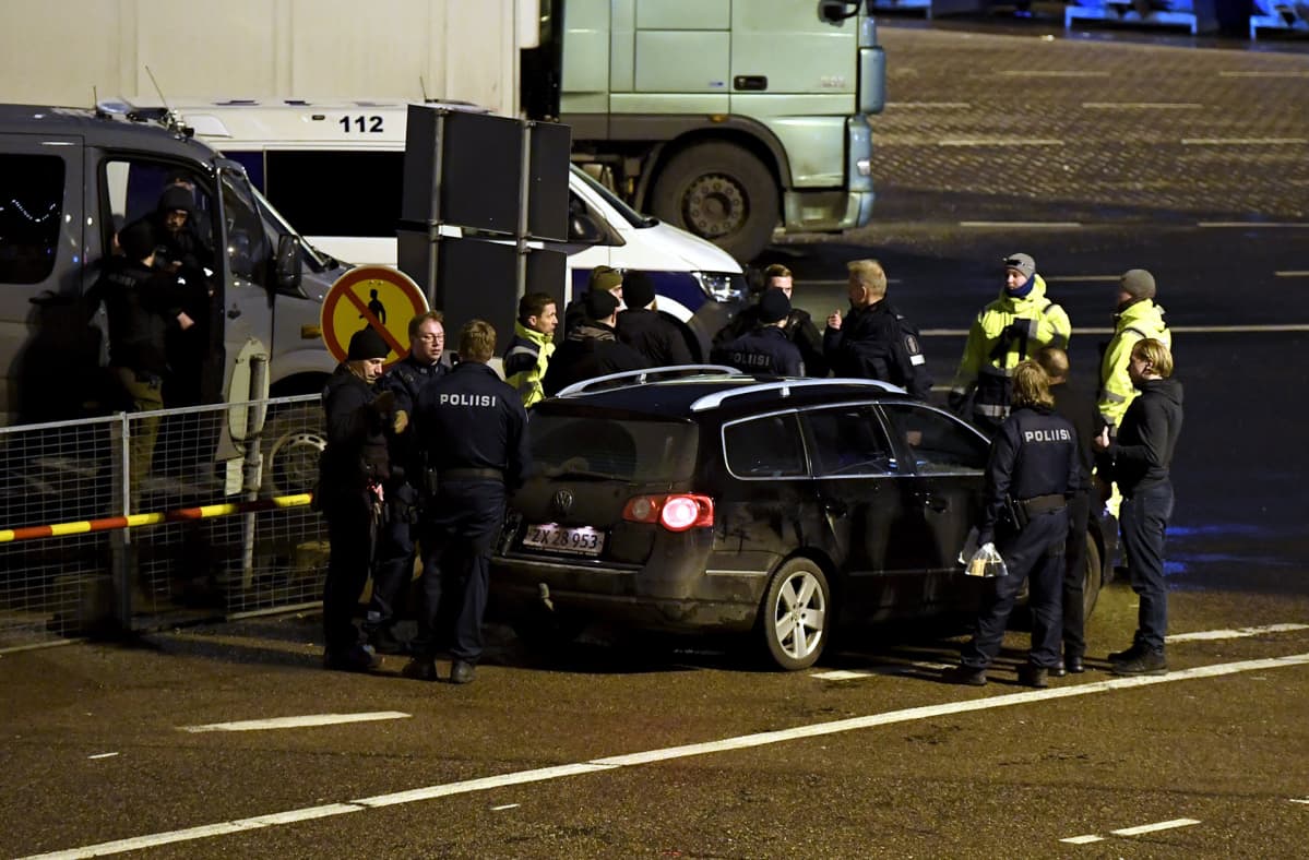 Poliisin etsintäkuuluttama musta Volkswagen Passat henkilöauto ja poliiseja Olympiaterminaalissa.