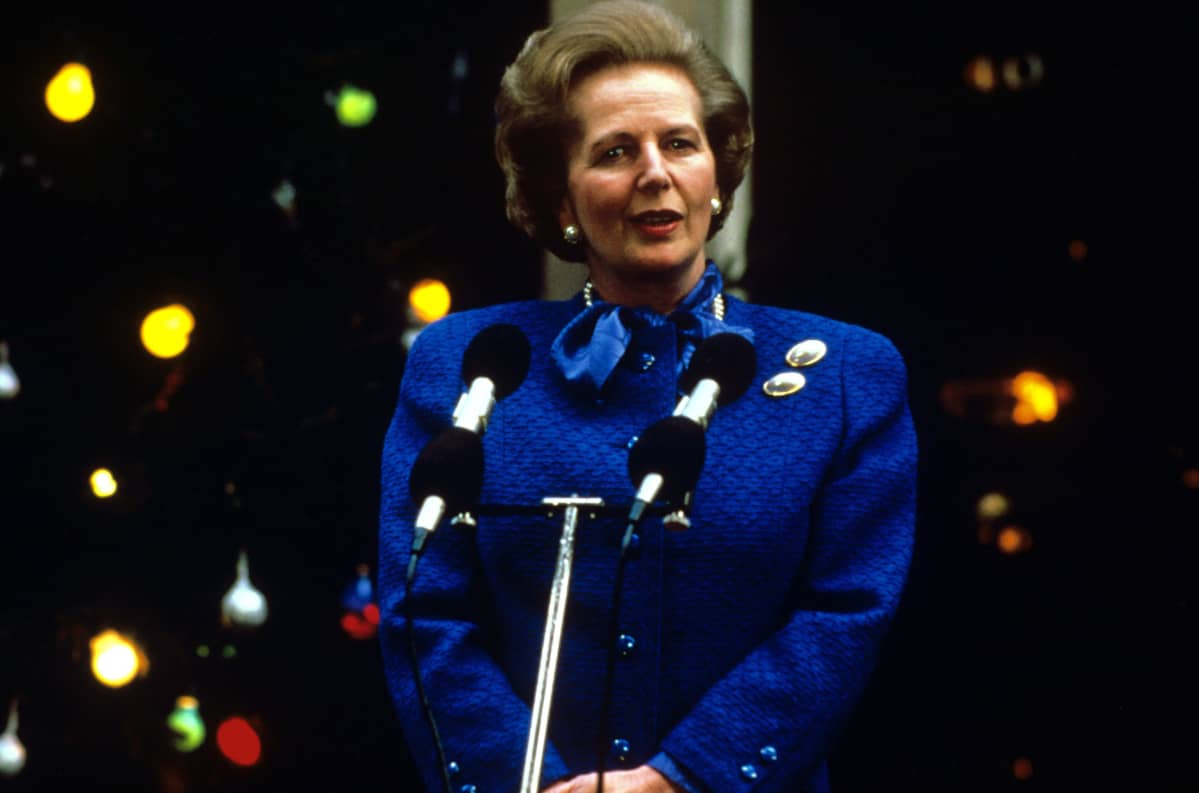 Siniseen asuun pukeutunut Thatcher puhumassa.