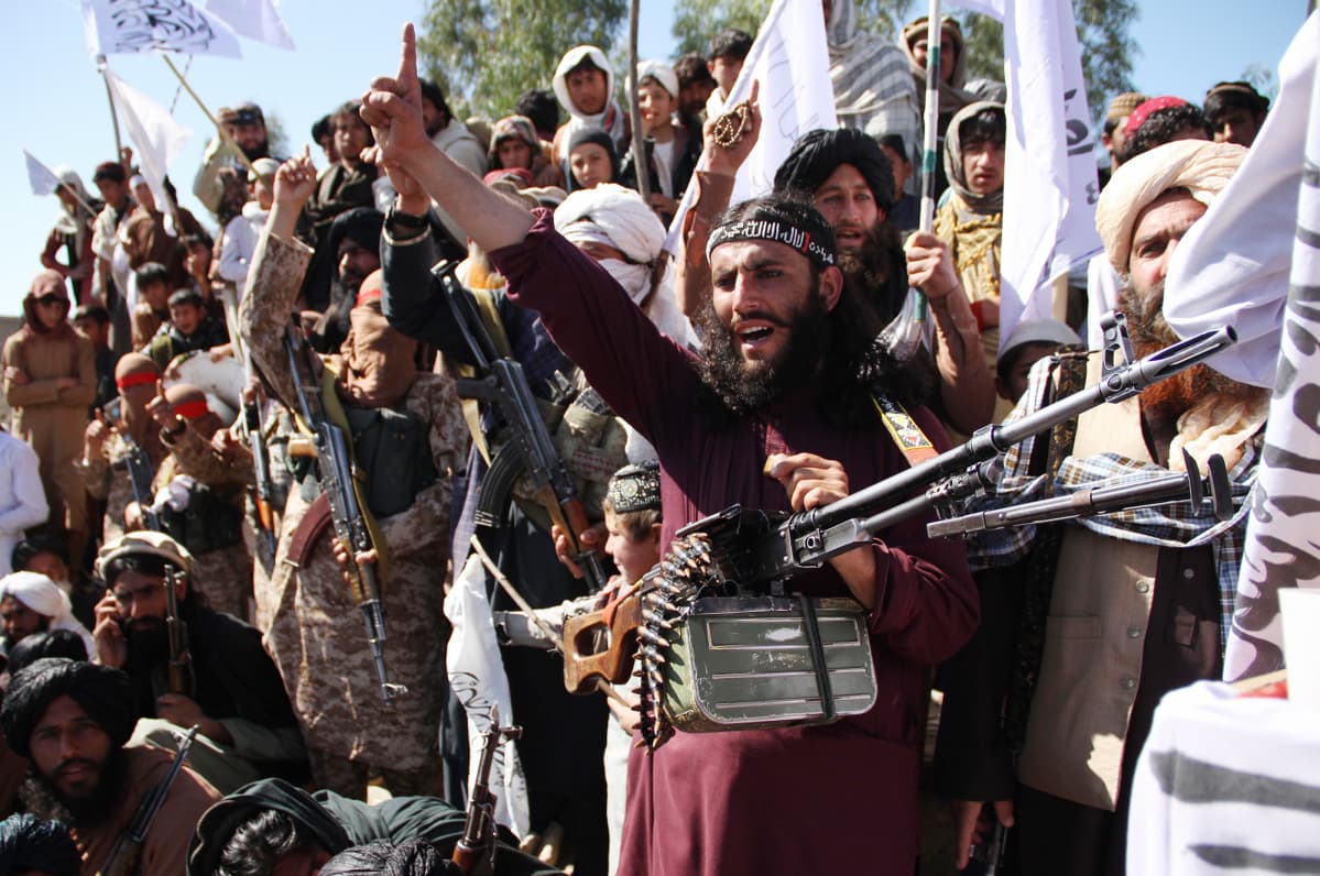 Afghanistanilaiset Taliban-sotilaat ja kyläläiset juhlivat Yhdysvaltain ja Talibanin välistä rauhansopimusta.