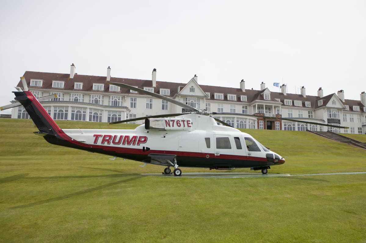 Helikopteri laskeutuneena lähelle hotellia. Kopterin kyljessä lukee Trump.