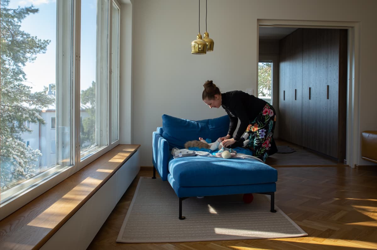 Eeva Kalmanlehto pukee vauvalleen ulkovaatteita.