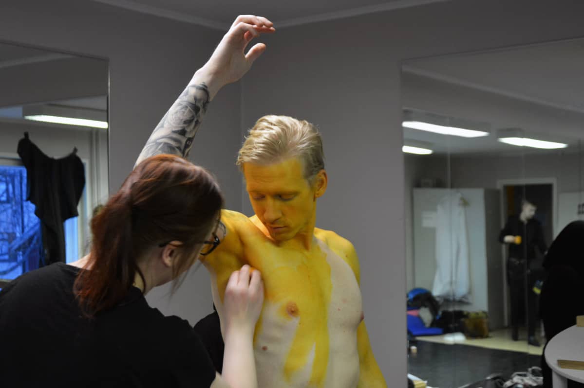 Näyttelijä Mikko Sippolaan maalataan kultamaalilla.