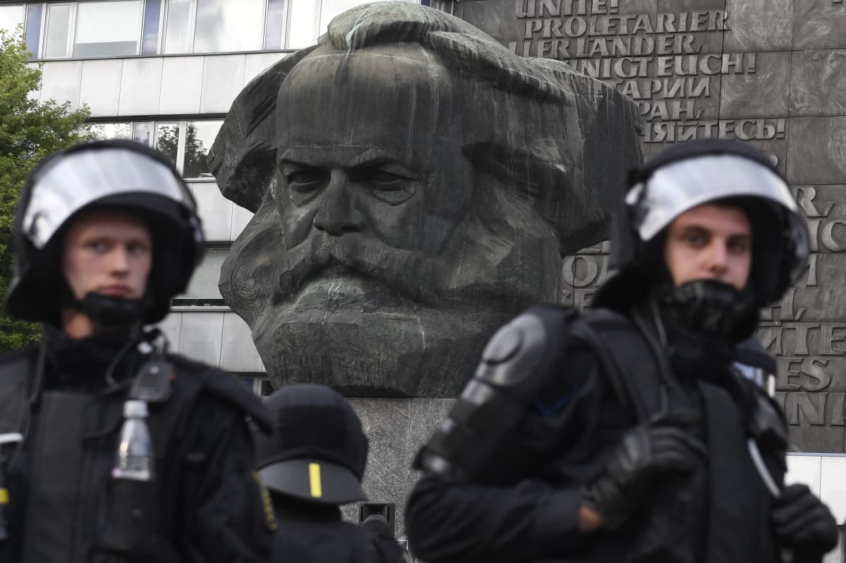 Chemnitzissä poliiseja Karl Marxin patsaalla, jonka vieressä mielenosoittajat kokoontuivat.