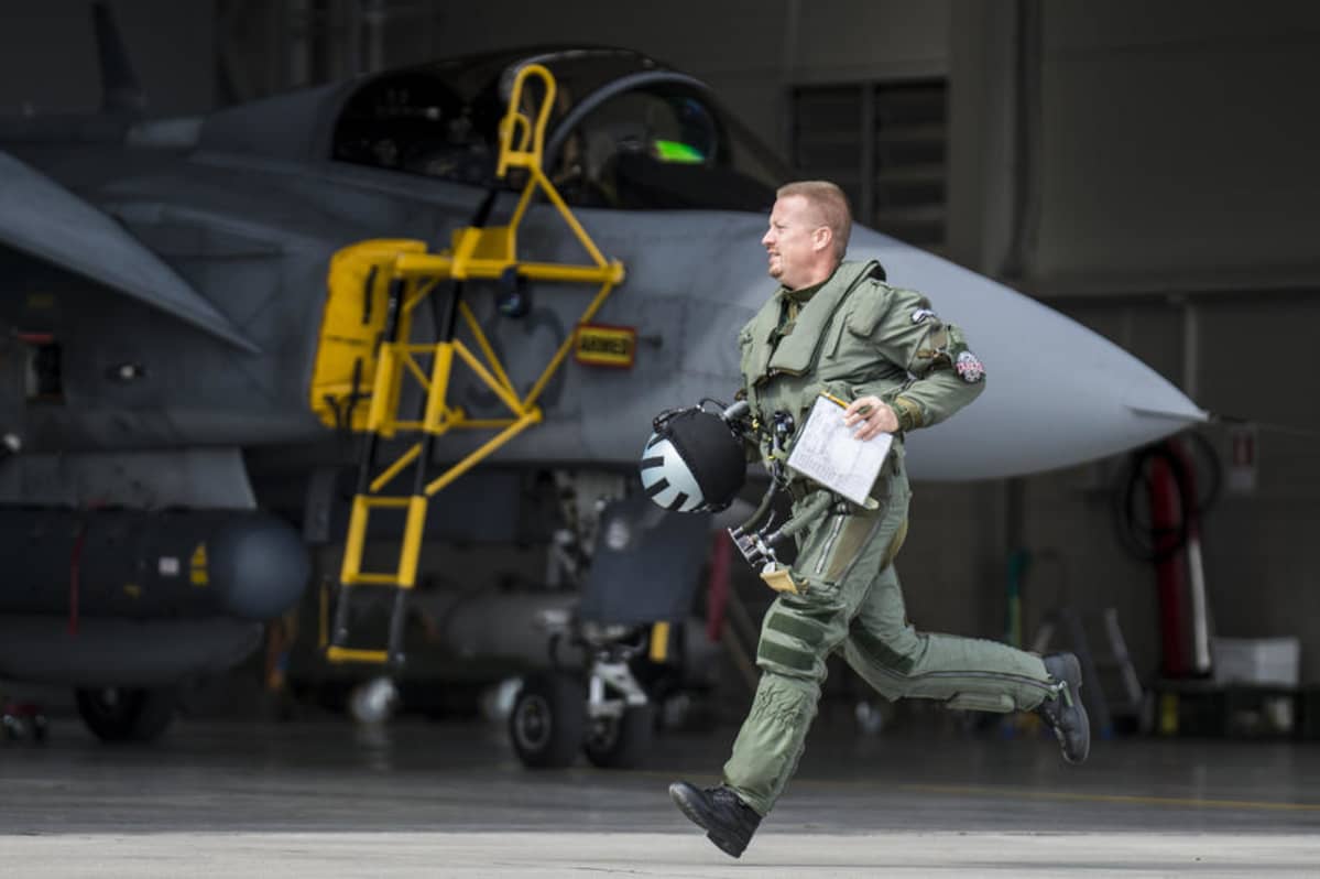 lentäjä juoksee gripen-hävittäjän ohi