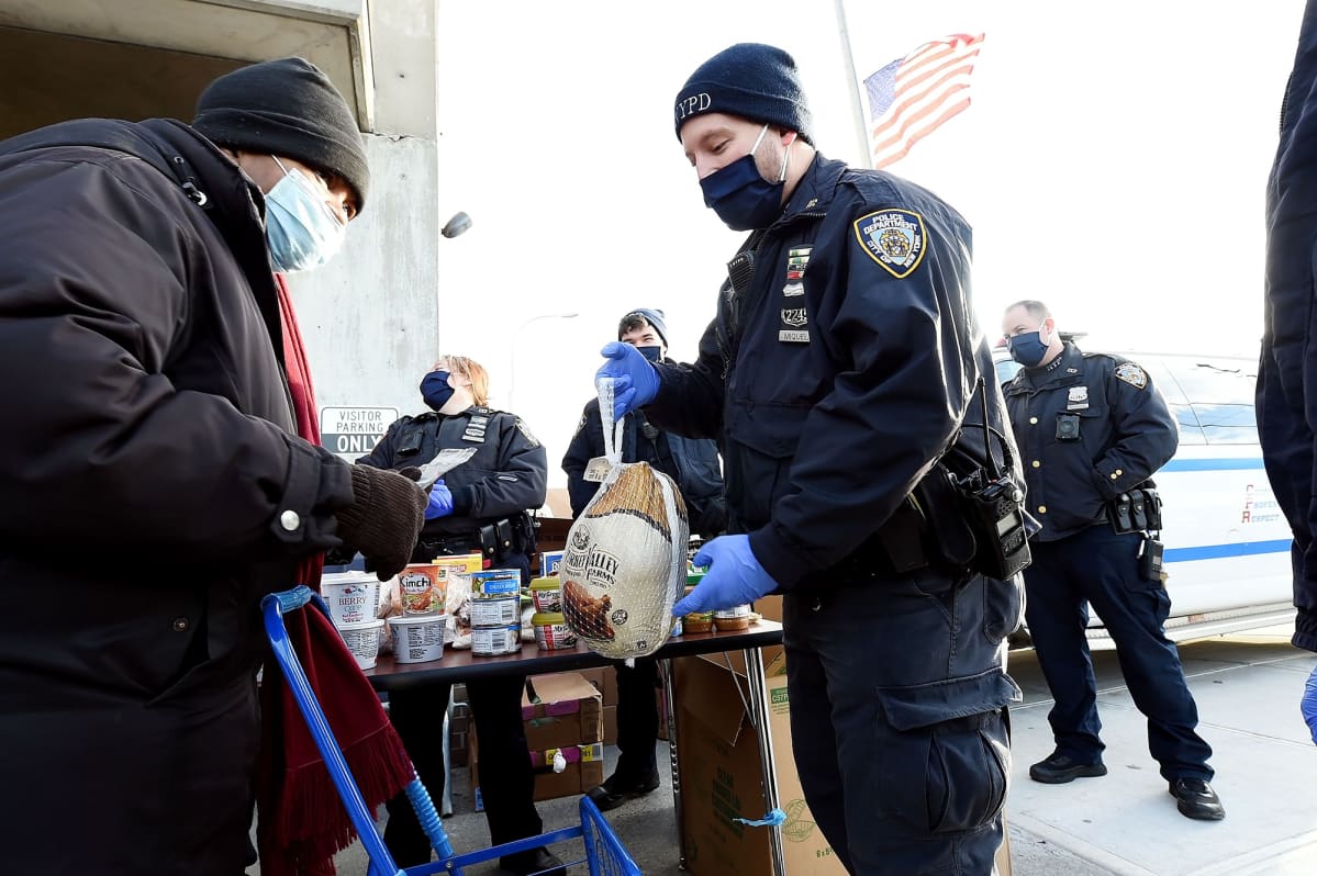 Poliisi antaa kalkkunan henkilölle hyväntekeväisyystilaisuudessa New Yorkissa.