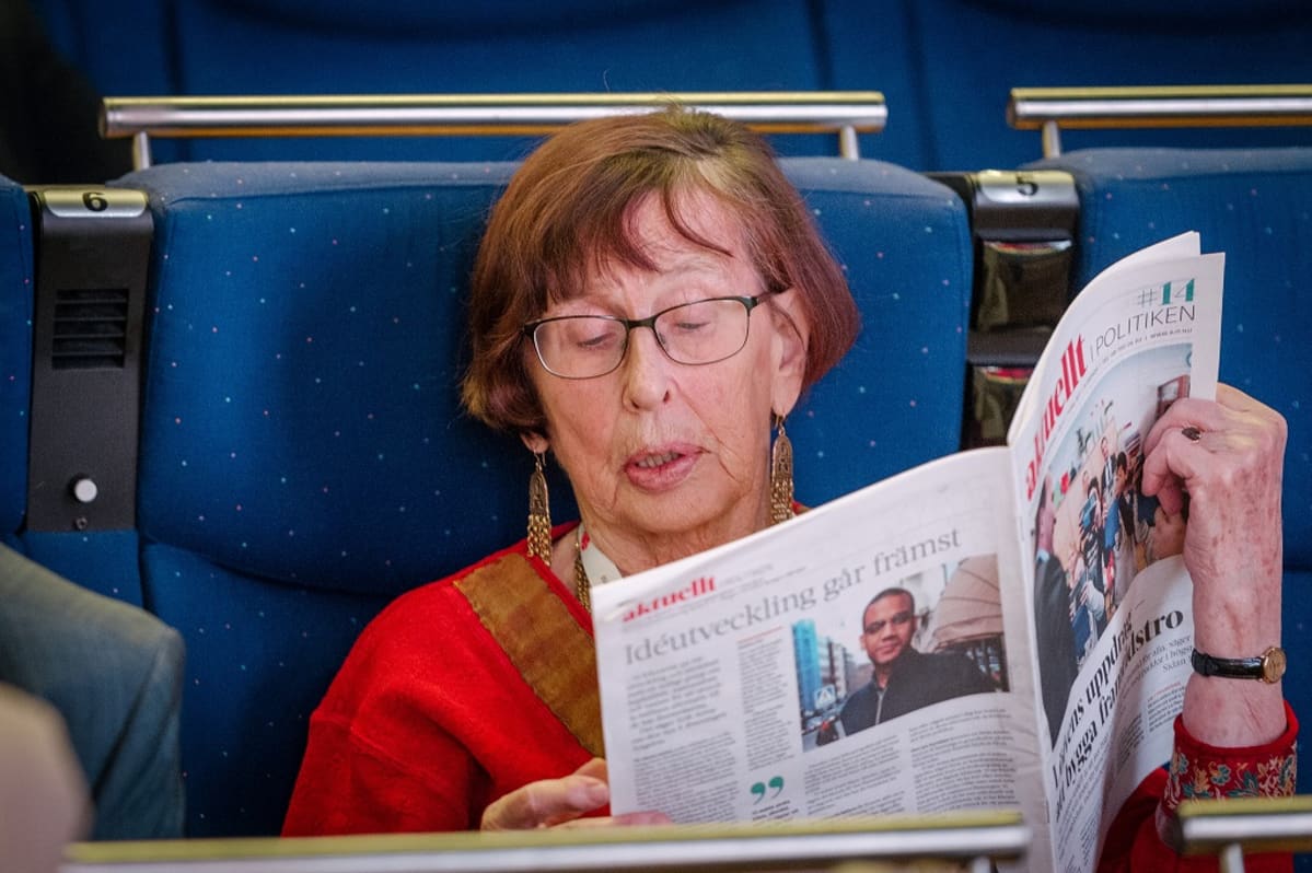 Birgitta Dahl lukemassa sanomalehteä.