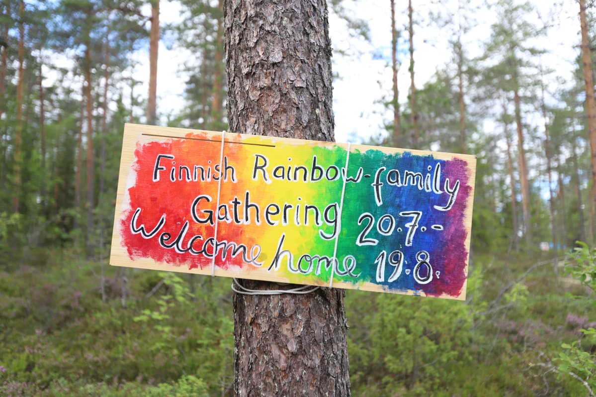 Puussa roikkuu kyltti, joka toivottaa Rainbow-perheen tervetulleeksi leirille