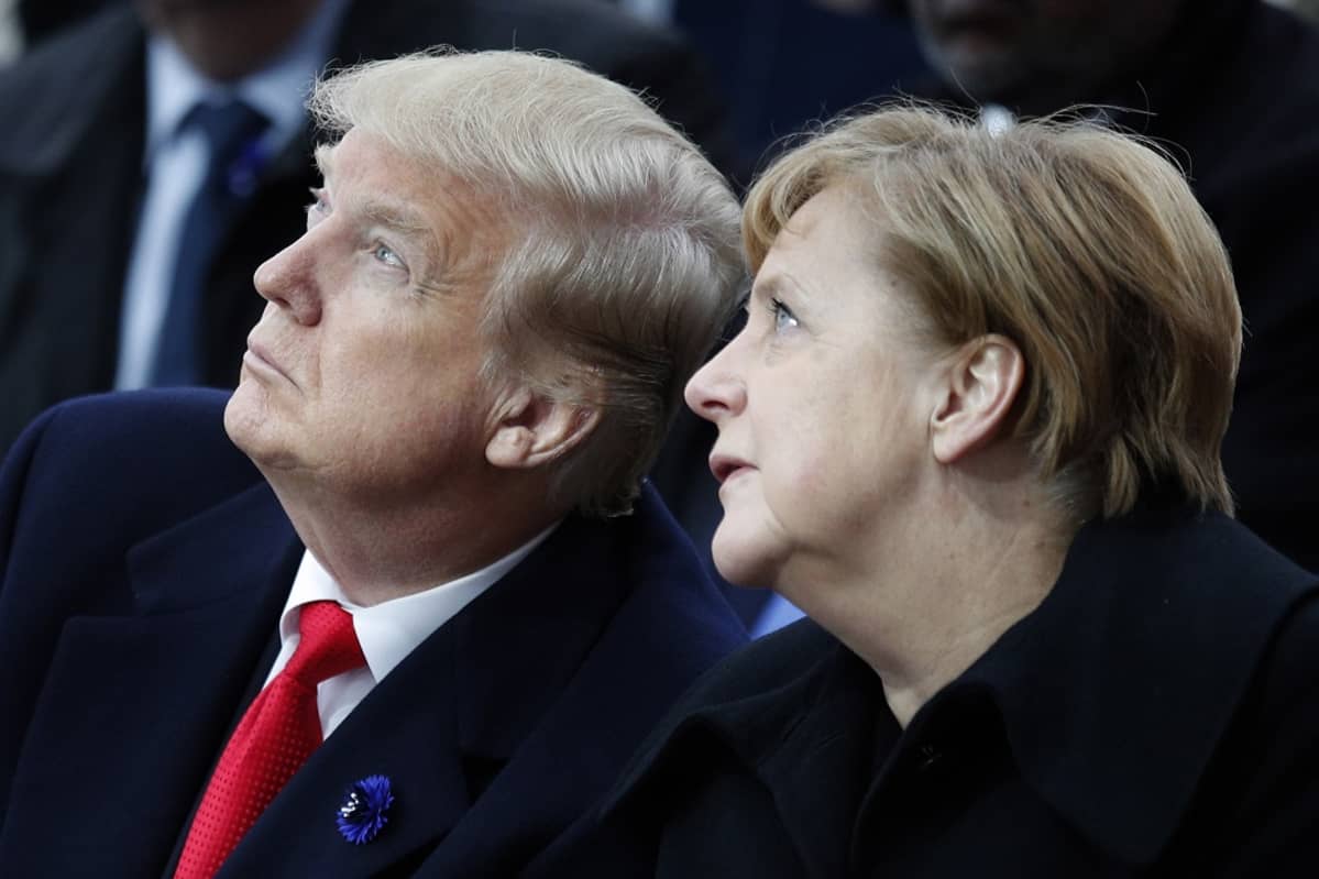 Kuvassa Donald Trump ja Angela Merkel istumassa vierekkäin. Molemmat katsovat yläviistoon.