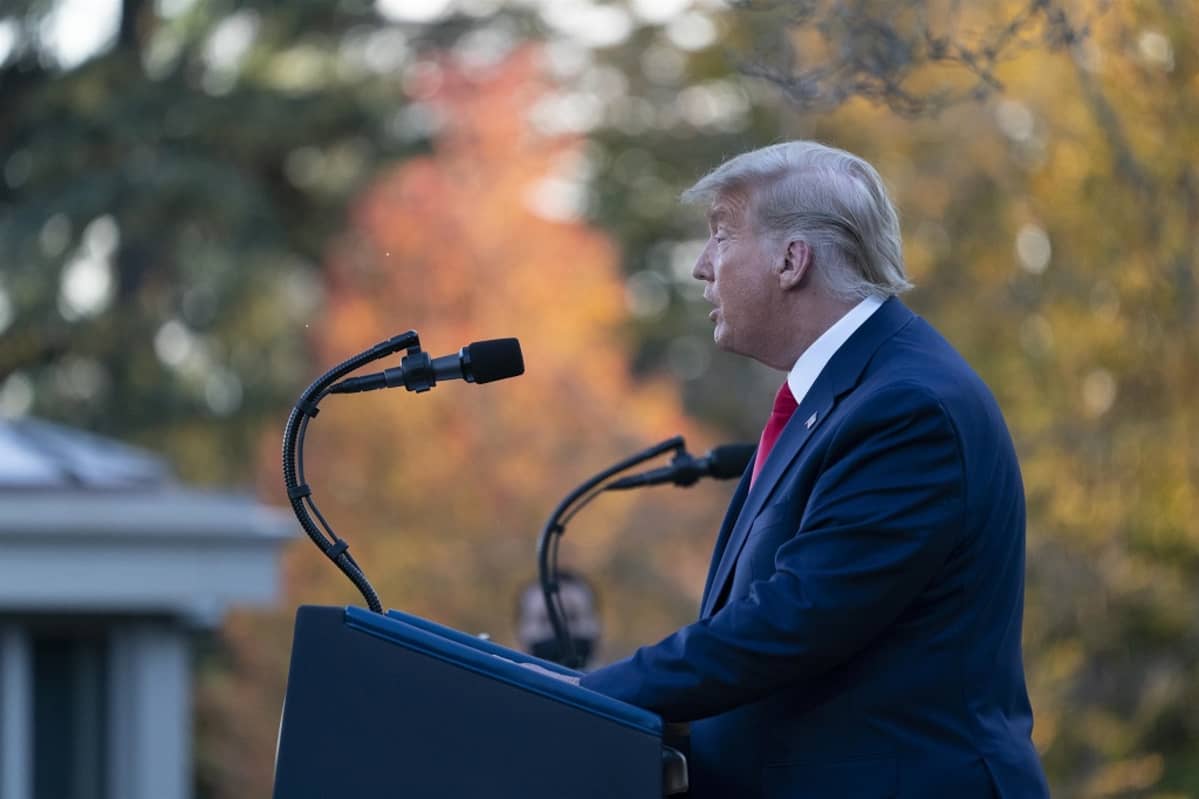 Trump kuvattu profiilista Valkoisen talon pihalla.