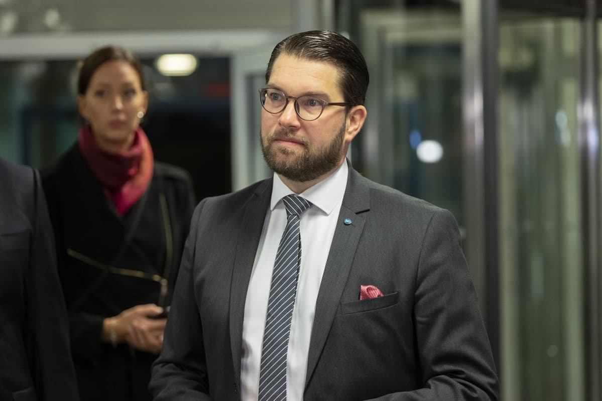 Åkesson puolikuvassa, tumma tausta.