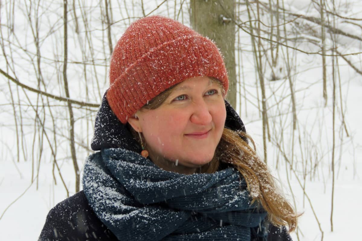 Anna Haukka lumisateisessa metsässä