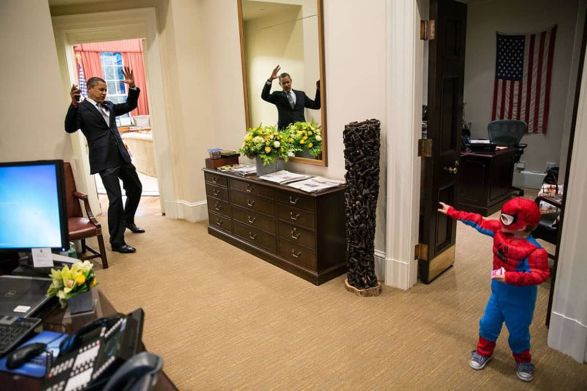 Barack Obama ja lapsi joka on pukeutunut hämähäkkimies-asuun