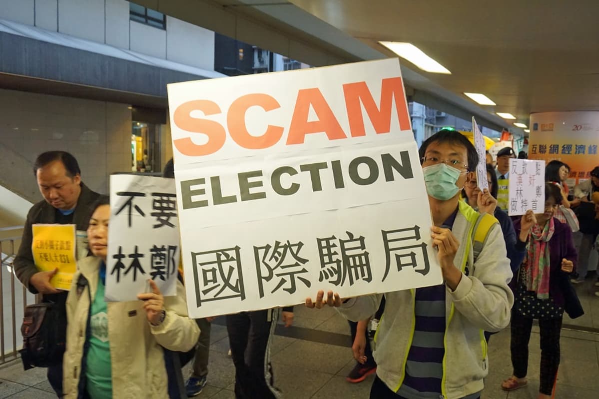 Ihmisiä, kyltti: "Scam Election".