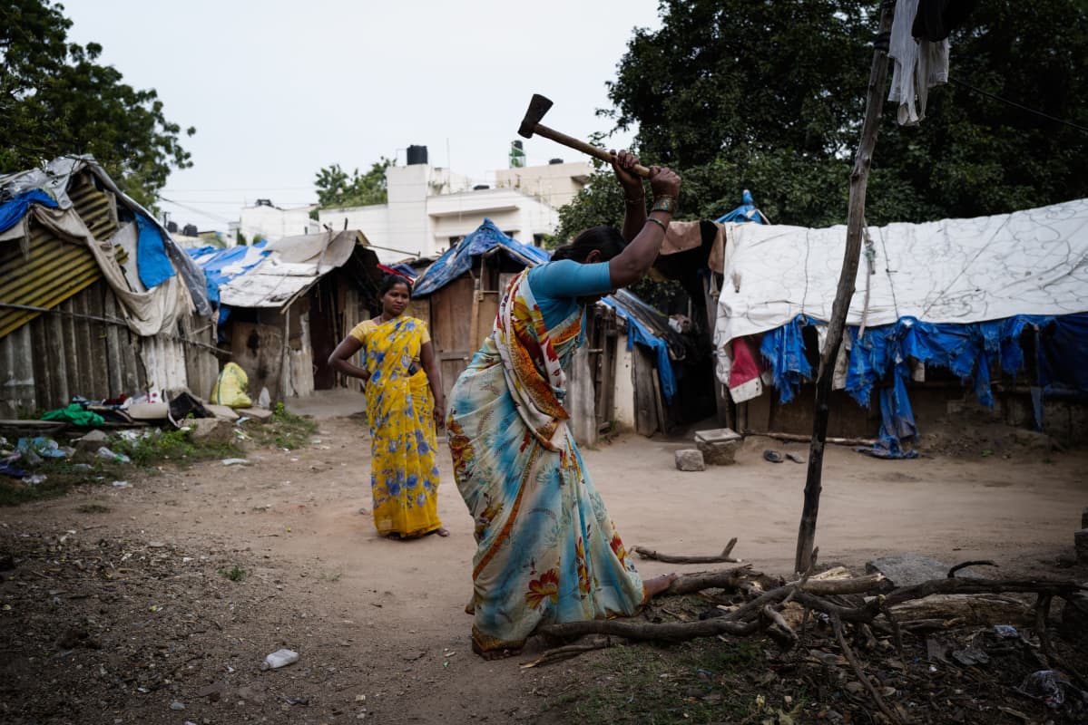 Naiset hakkaavat polttopuita Kagadu Bastin slummialueella Hyderabadin kaupungissa Intiassa.