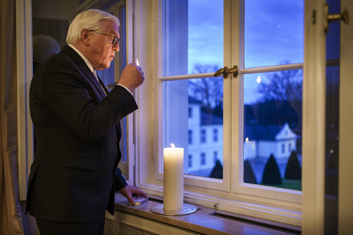 Saksan liittopresidentti Frank-Walter Steinmeier sytytti ikkunalle kynttilän koronauhrien muistoksi