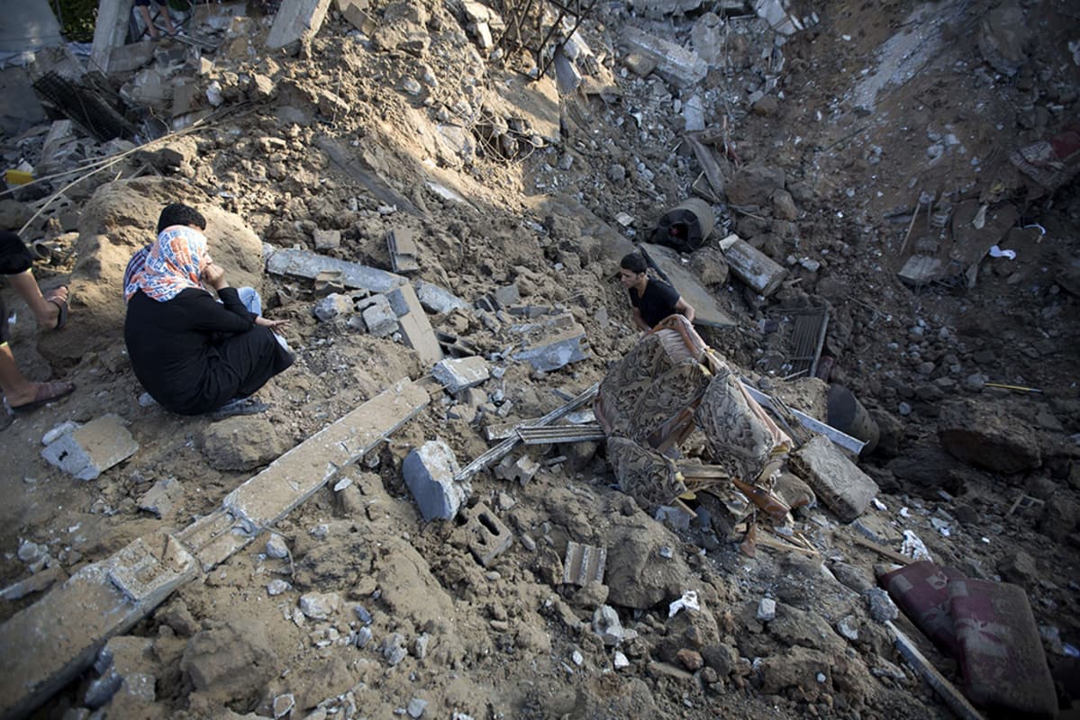 Palestiinalaismies kerää tavaroitaan Israelin ilmaiskussa tuhoutuneesta kodistaan Beit Hanussa, Gazassa 9. heinäkuuta 2014.
