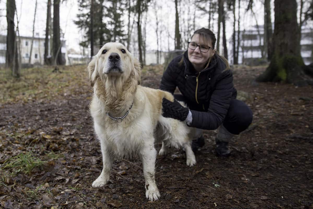 Katja poseeraa kultaisen noutajansa, Nougatin kanssa, puistossa.