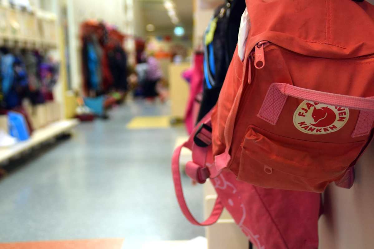 En ryggsäck hänger på en knagg i en skolkorridor.