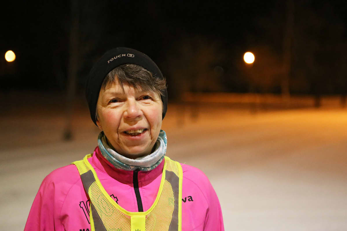 Nainen seisoo lumisella tiellä.