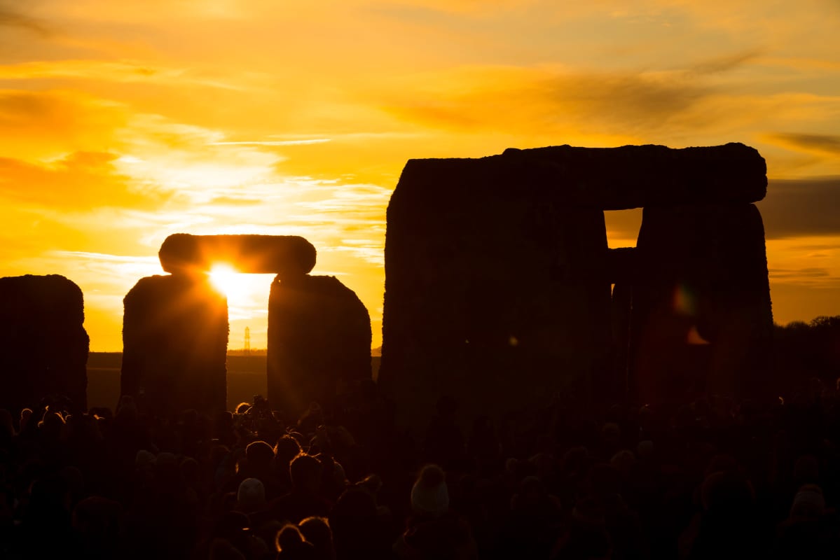 Talvipäivänseisauksen juhlijoita Stonehengellä Wiltshiressä Britanniassa auringonnousun aikaan 22. joulukuuta 2019.