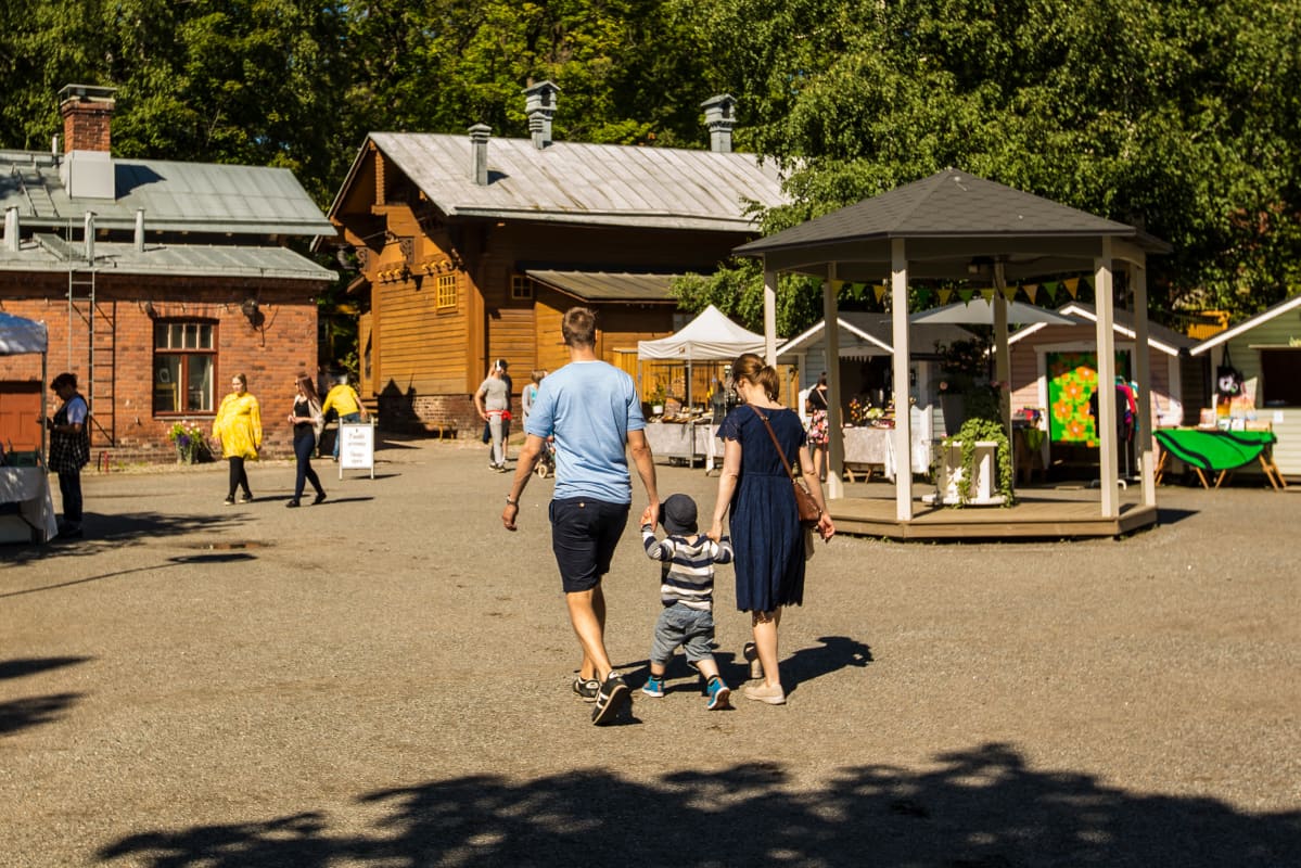 Lapsiperhe Tallipihalla heinäkuussa. Kuvituskuva.