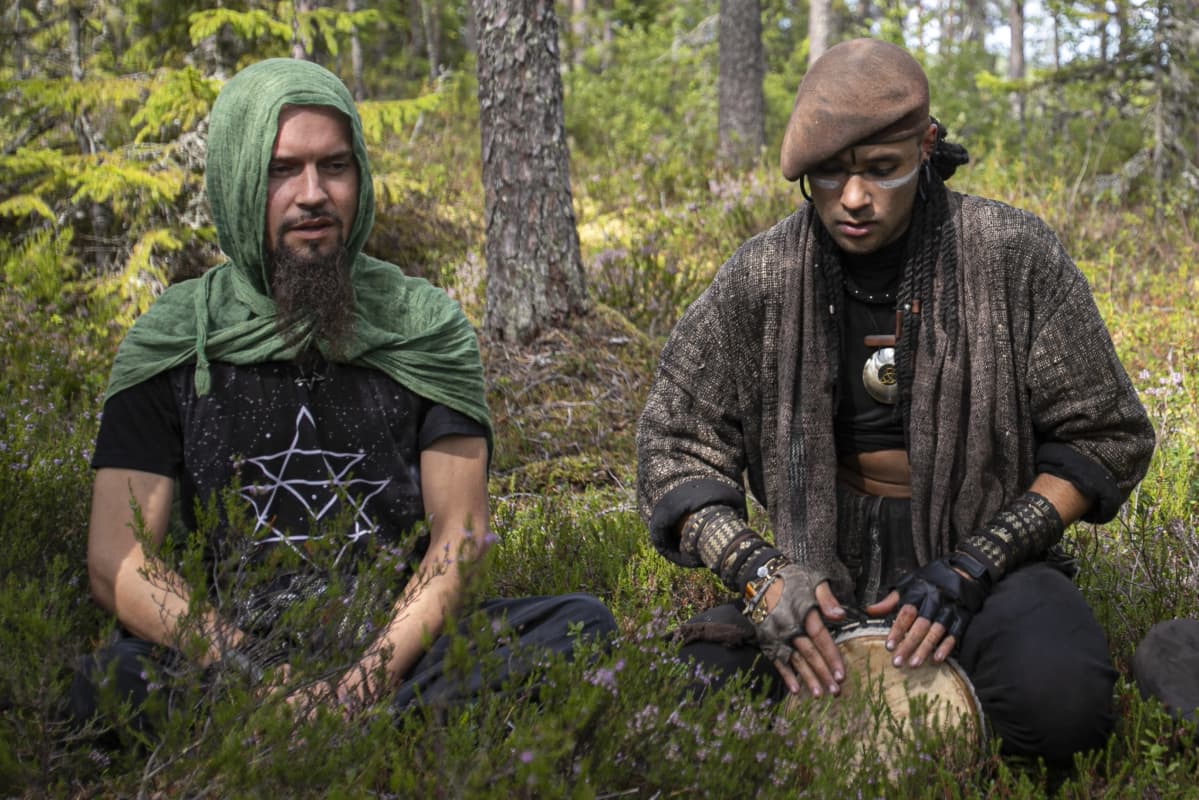 Kaksi Rainbow-leirin hippiä soittaa ja laulaa metsässä