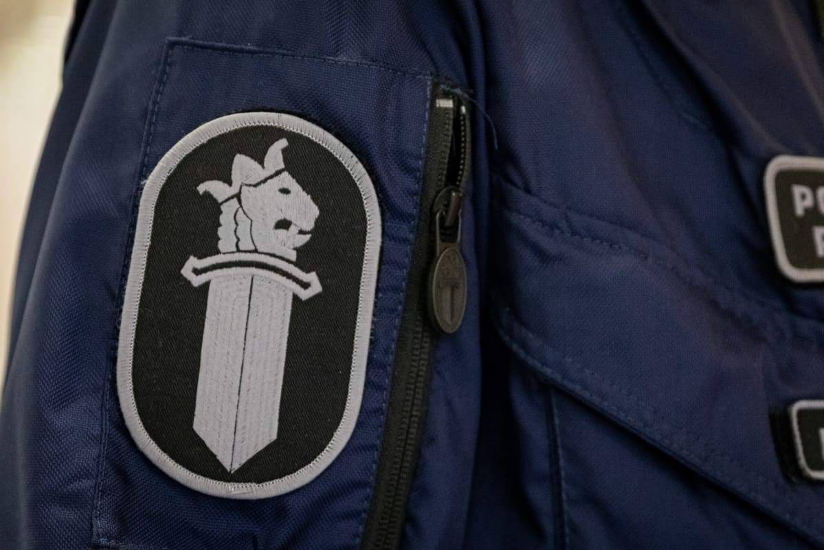 Poliisin virkamerkki työhaalarin hihassa