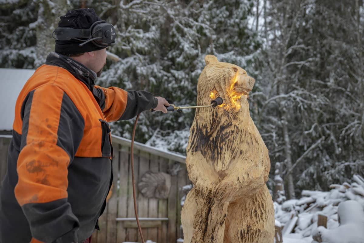 Raimo Hautaluoma pintakäsittelee puukarhua