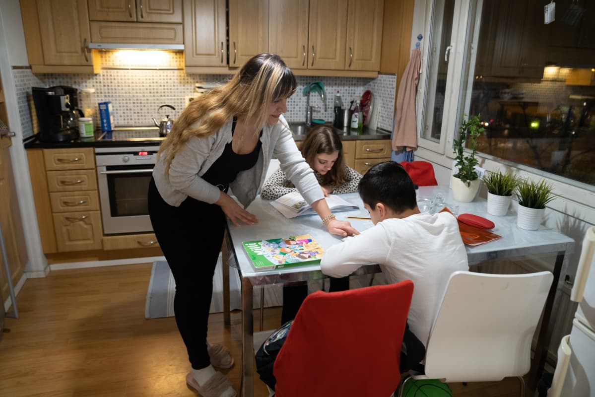 Mirna Alsaddir auttaa lapsiaan läksyjen teossa.