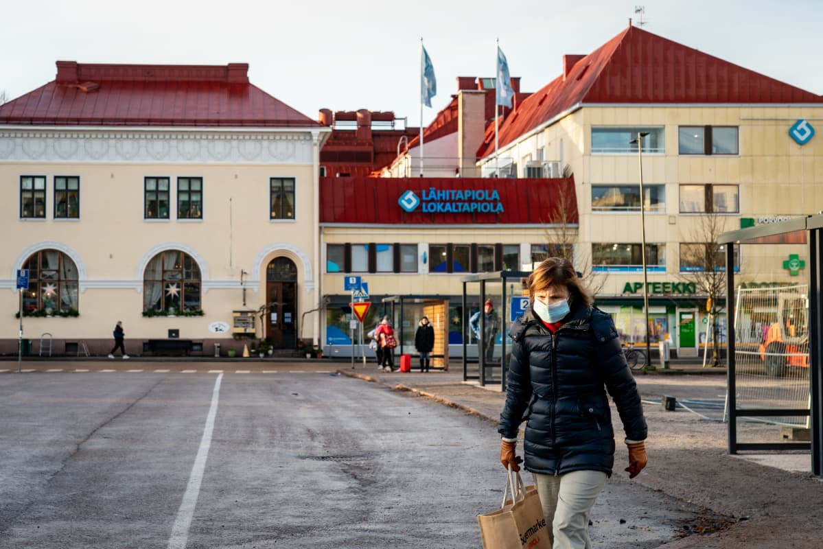 Nainen kasvomaskissa Porvoon torilla.