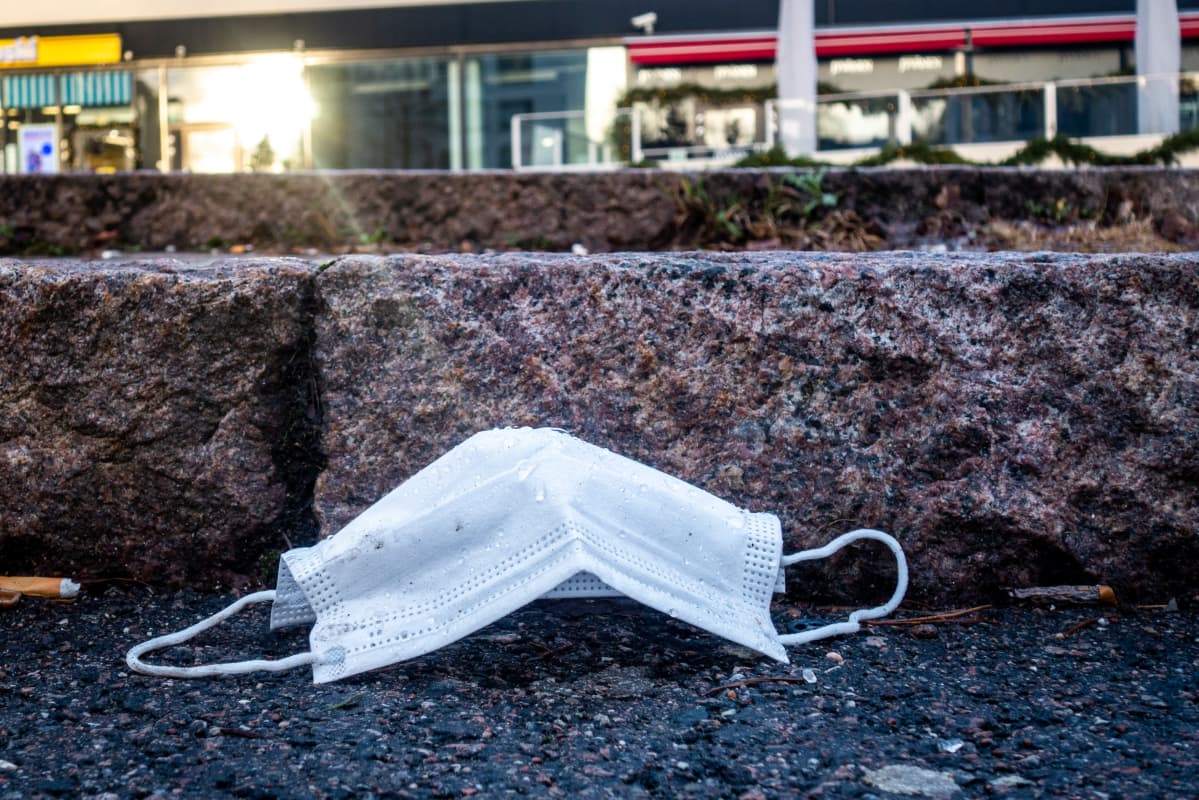 Pois heitetty kasvomaski asfaltilla ostoskeskuksessa.