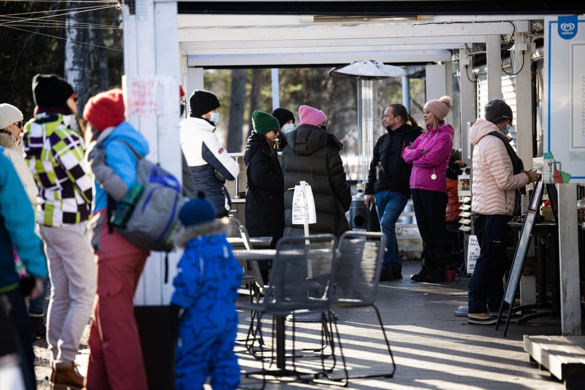 Ihmisiä jonottaa kahvila-ravintolan ulkoluukulla tilatakseen.