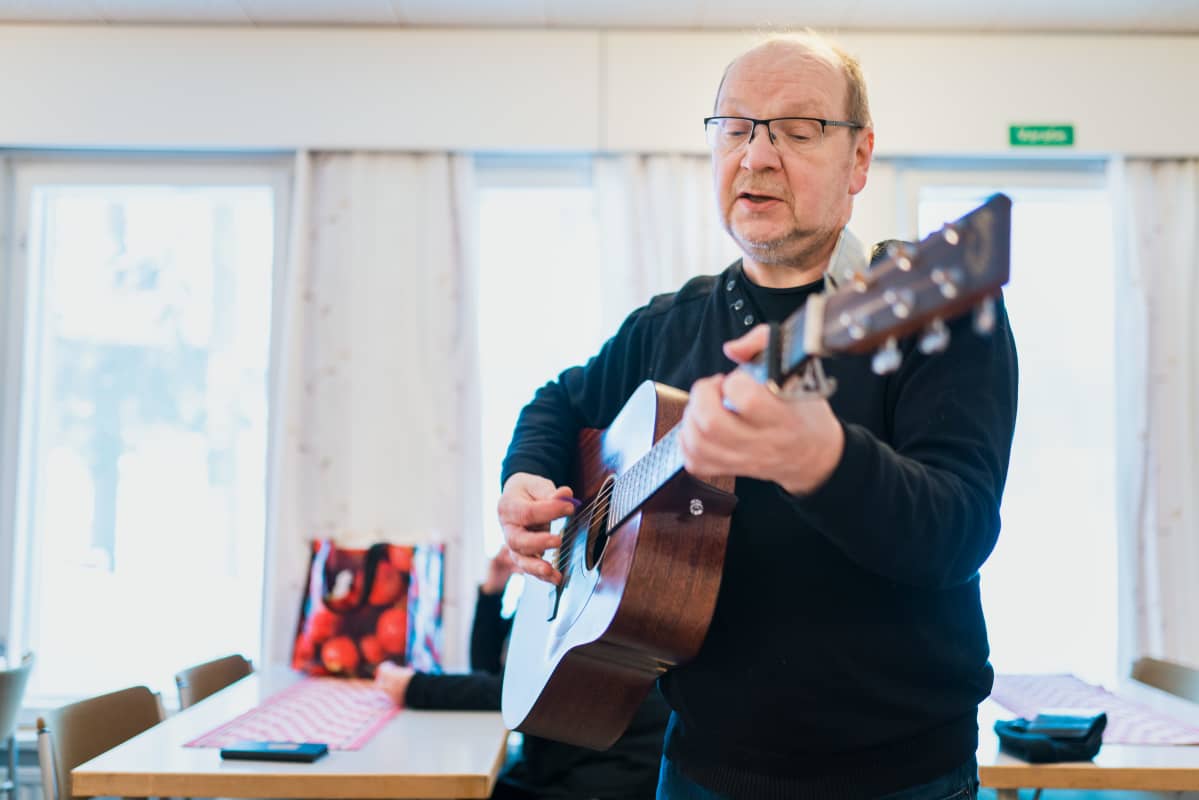 Mies soittaa kitaraa
